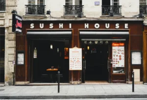 一家名为“Sushi House”的日本料理寿司餐厅外观，展示了餐厅门面及菜单。