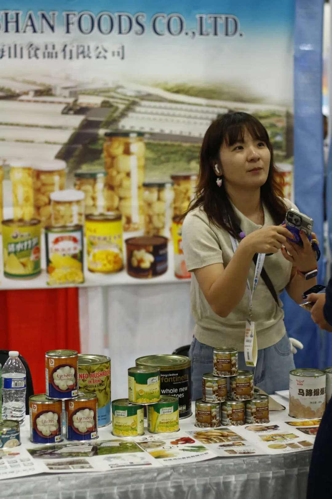 缙山食品公司展台展示了各类罐装食品和食材，展台前有工作人员与参观者互动。