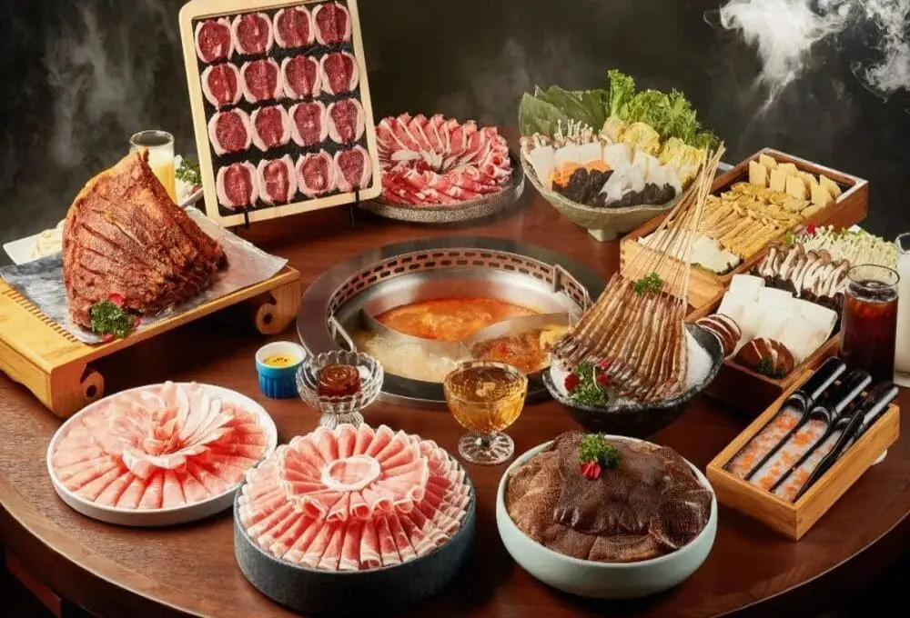 一锅鸳鸯火锅中央沸腾，周围摆满羊肉卷、牛棒骨、菌菇、蔬菜拼盘和各式丸滑，色香诱人。