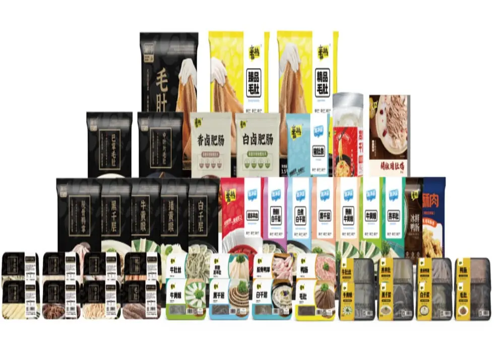展示亲热集团多个品牌旗下的火锅及预制菜产品，包括毛肚、肥肠、牛肉片、菌菇等包装商品，排列整齐。