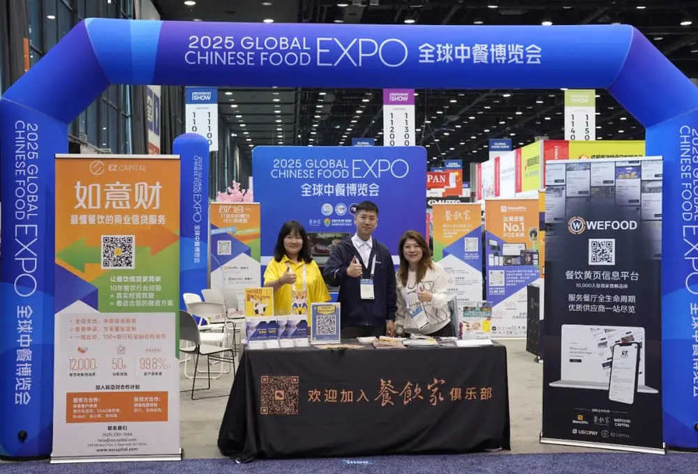 三位工作人员在全球中餐博览会2025展台前合影，背景展示“餐饮家俱乐部”及多家参展企业信息，展示餐饮数字化服务平台和黄页系统。