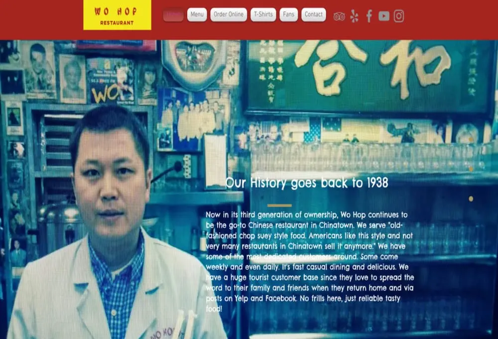 合和餐厅(Wo Hop)官网历史介绍页截图：顶部导航栏含"首页/菜单/在线订购/T恤/粉丝/联系"选项。核心区域展示身着白色工服的工作人员与中式装潢餐厅环境，醒目标题"OUR HISTORY goes back to 1938"下详细说明：第三代经营的老式炒杂碎餐厅，主打快速简餐，吸引大量游客通过Yelp/Facebook传播口碑，强调"无华丽装饰，唯有可靠美味"。