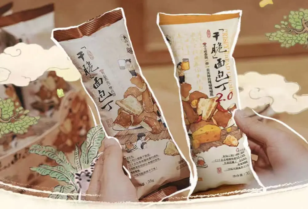 双手持茶研零食包装：左袋"云吞饭团"配蒸笼插画（橙红调），右袋"干脆面包丁"用书法字体（青黛色）。均标注净含量35g，背景水墨纹呼应"东方美学日常化"出海战略，小包装适配北美快消习惯。