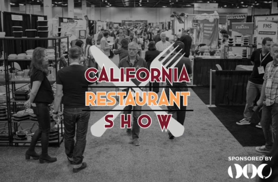黑白摄影展现CRS展厅实况：中央悬挂红橙渐变立体字「CALIFORNIA RESTAURANT SHOW」，下方「SPONSORED BY FMS PARADA」标识。两侧展位陈列设备/食材，密集人流穿梭洽谈。全景呈现1200+供应商与12000+决策者规模，TOA亚洲展区集成于此产业资源中枢。